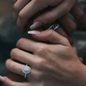 Close-up of couple holding hands showing diamond engagement rings.
