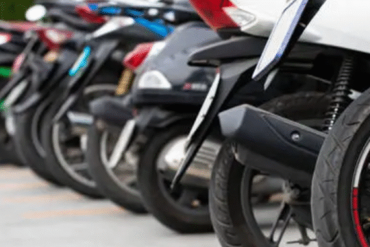 Row of parked motorcycles and scooters in an outdoor lot