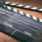 Empty black and white clapperboard resting on a wooden surface, ready for film production.