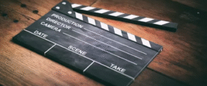 Empty black and white clapperboard resting on a wooden surface, ready for film production.