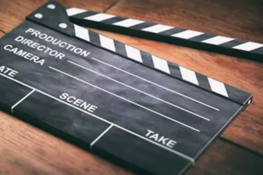 Empty black and white clapperboard resting on a wooden surface, ready for film production.
