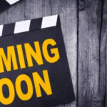 Clapperboard with “COMING SOON” text on wooden background