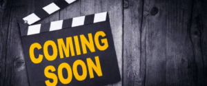 Clapperboard with “COMING SOON” text on wooden background