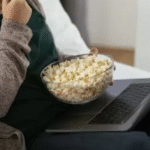 a girl watching movie and enjoying her popcorn