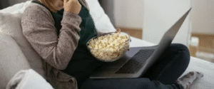 a girl watching movie and enjoying her popcorn