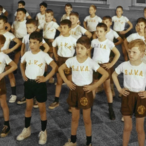 Students in uniform shorts and t-shirts pose for a group photo.