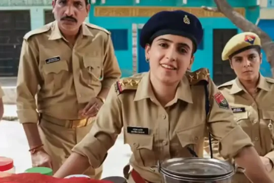 Sanya Malhotra as a police officer at a village stall.