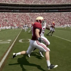 A football game with players on a field and a crowded stadium.