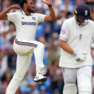 Indian cricketer celebrates a wicket during a test match, with the batsman walking away.