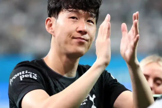 South Korean footballer Son Heung-min clapping in a stadium.